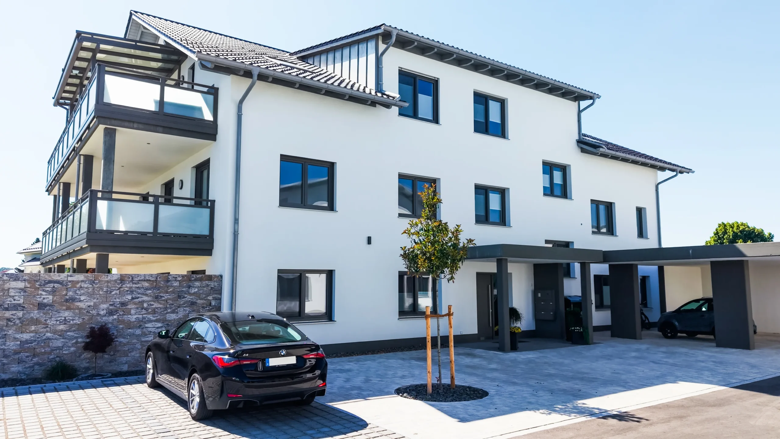Seitenansicht des Bürogebäudes von Bau & Putz in Rammingen mit Eingang und Hof