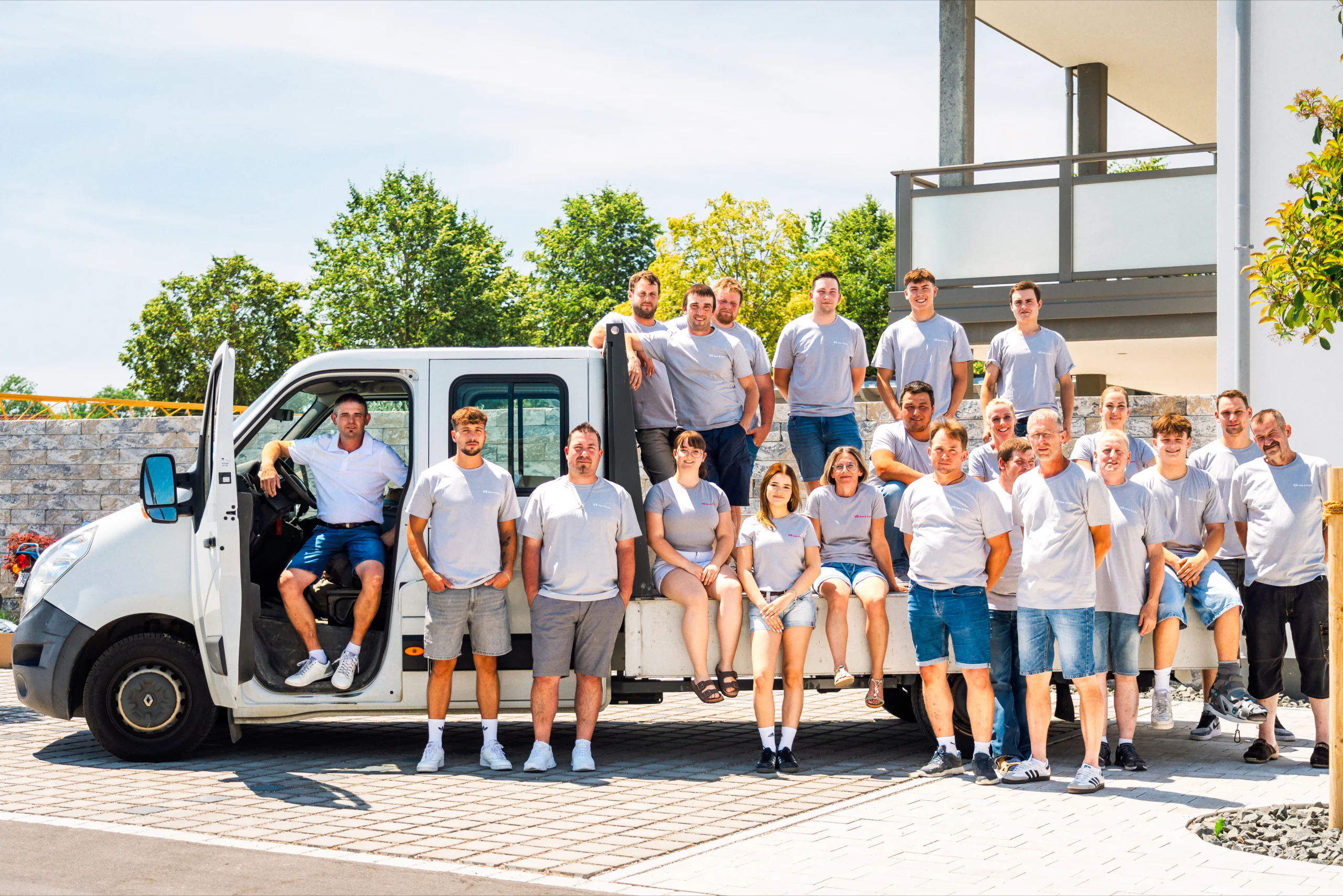 Team von Bau & Putz vor einem Firmenfahrzeug